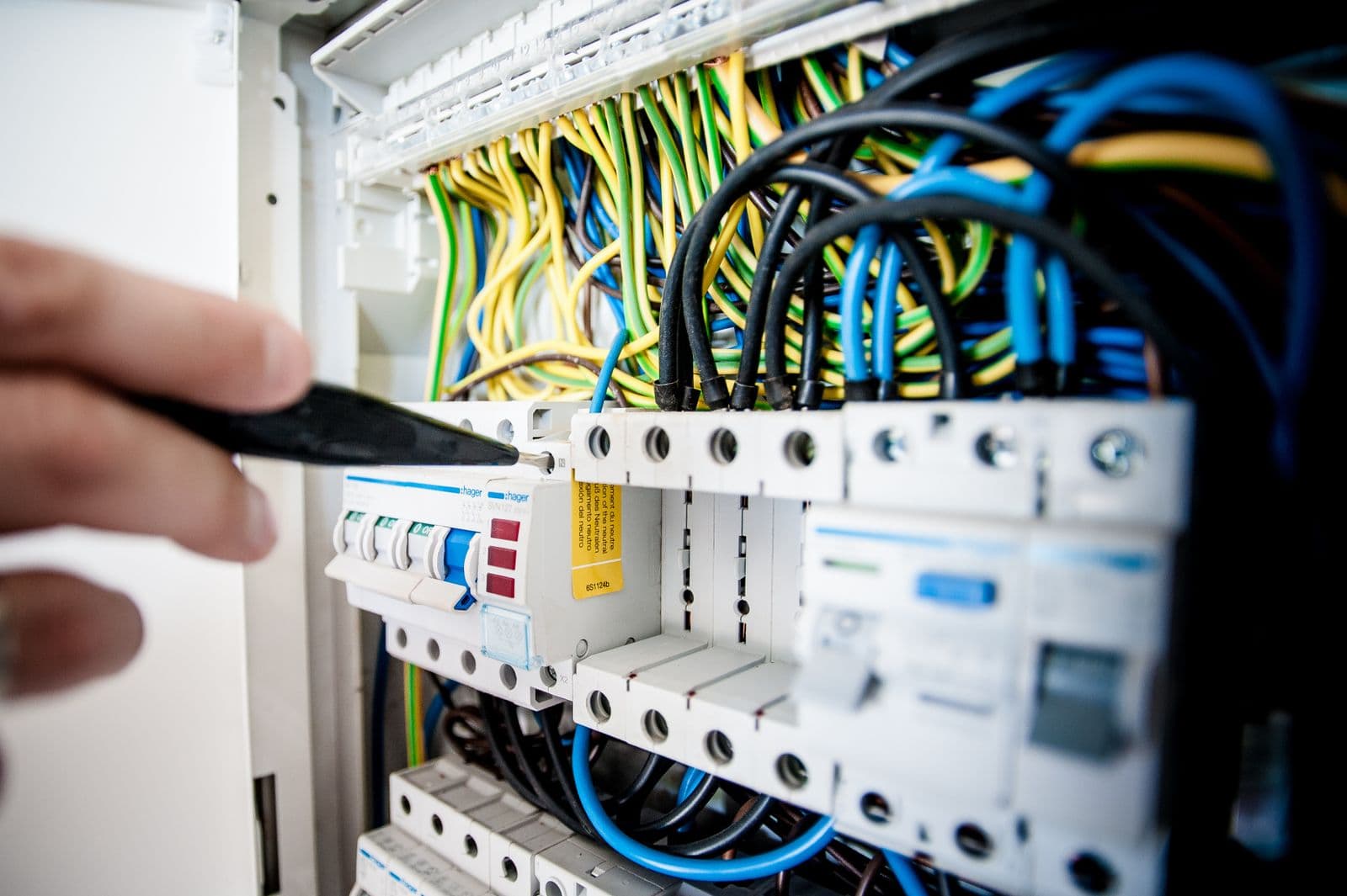 Electrician tightening a connection inside a distribution board