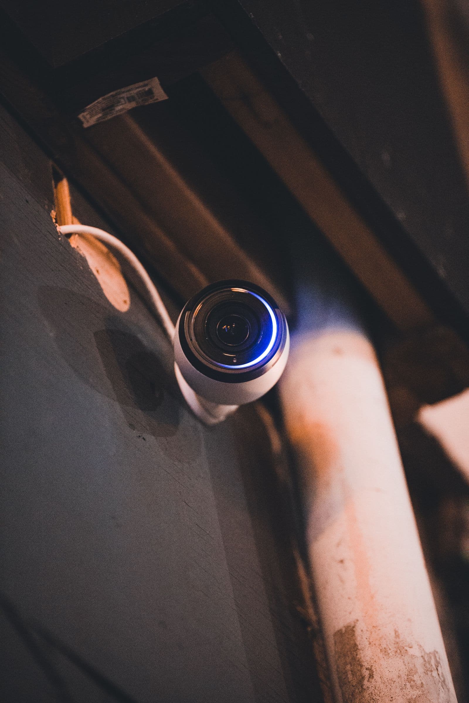 Wall-mounted CCTV camera with its cable visible